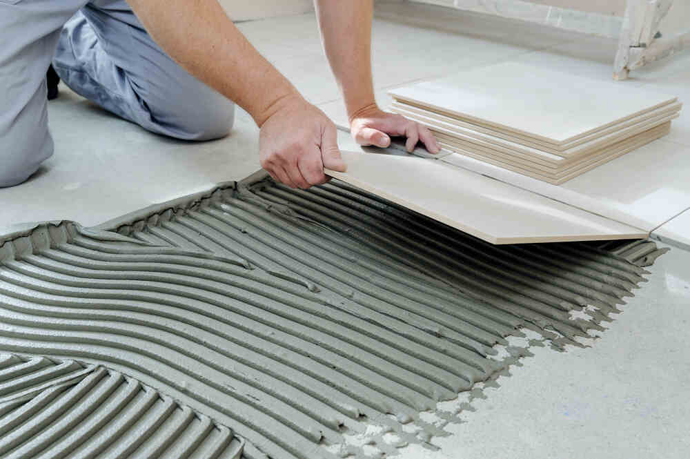 A man installing a tile floor